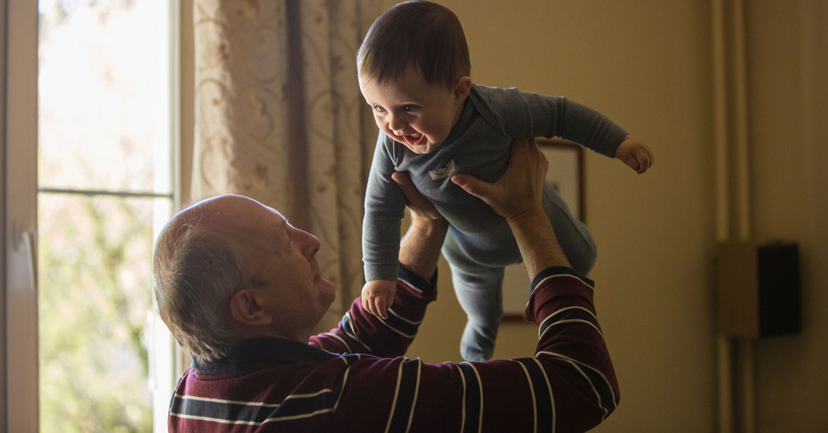 grandfather lifts baby