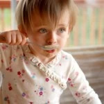 child eating soup
