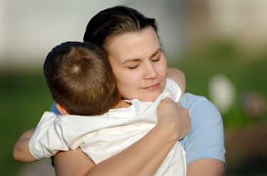 iStock - mom hugging her son tightly 2