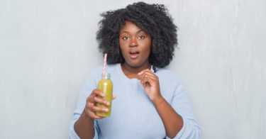 woman juicing cabbage and kale