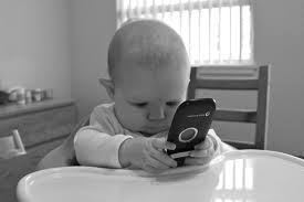 baby playing with a cell phone, modern family, modern parents
