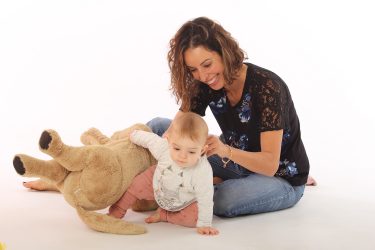Peggy Economou with her newborn baby and a teddy bear