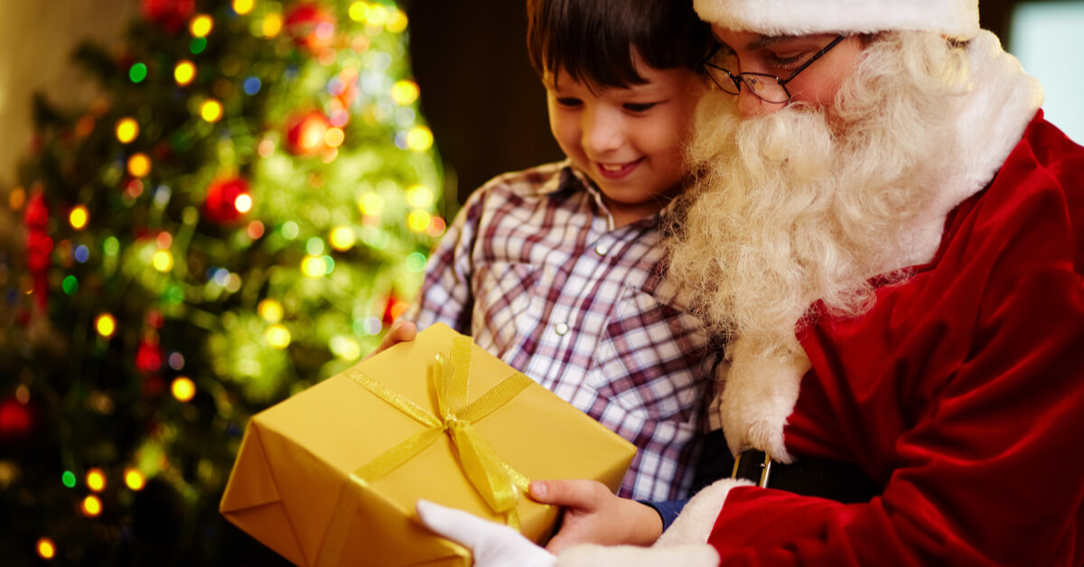 Boy holding a gift with Santa