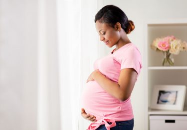 pregnant woman cradles belly