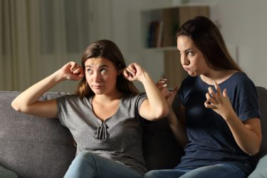 girl with fingers in her ears frustrates mother