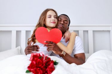biracial valentines couple in bed