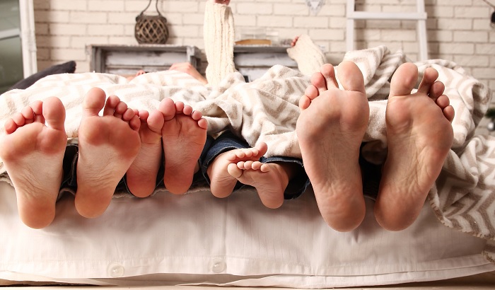 family in bed, only feet showing
