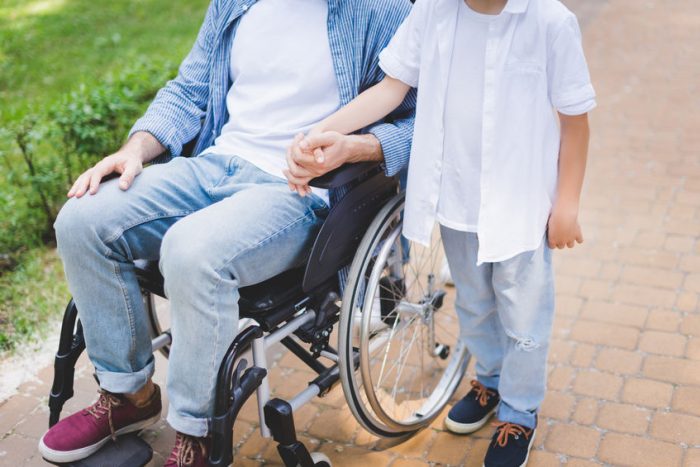 disabled father holding hands with son