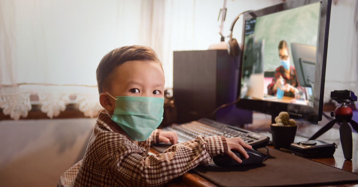 boy in facemask at computer
