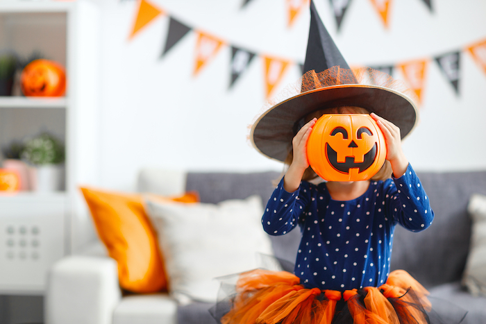 Kid in halloween costume with pumpkin