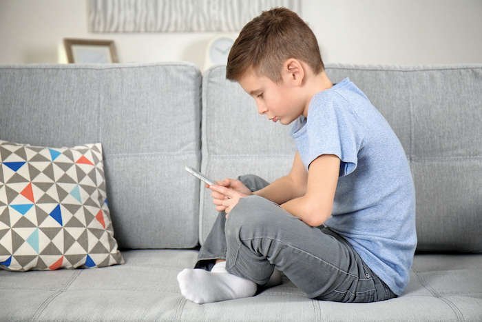 Boy leaning over tablet