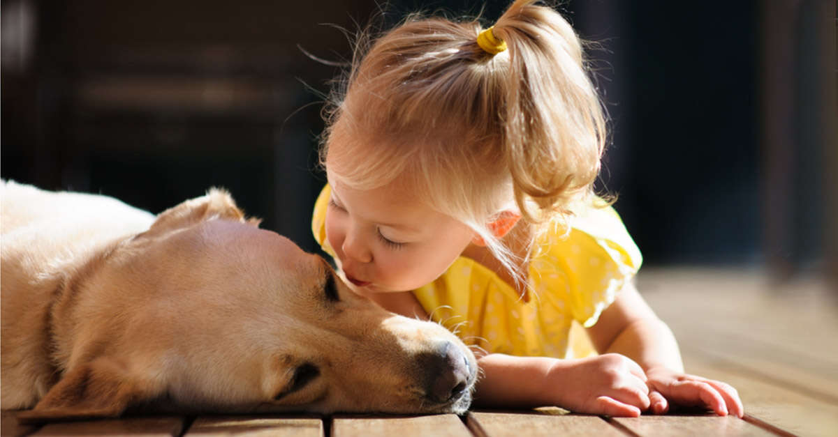 girl kissing dog