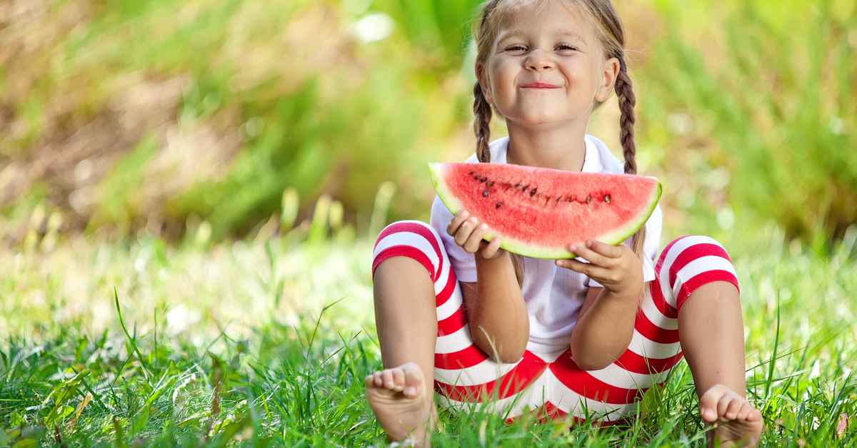 child eating watermelon on grass