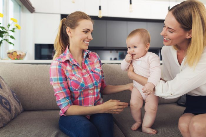 mom giving baby to nanny