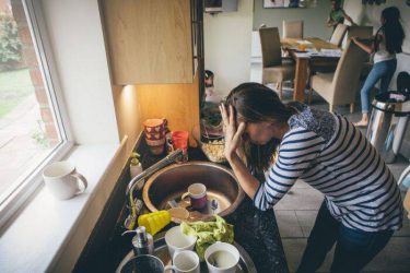 anxious mother hunched over sink